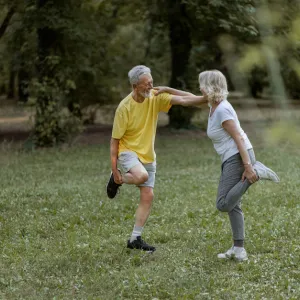 Twee mensen stretchen buiten in een park