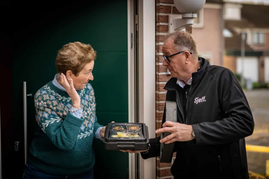 Dame ontvangt maaltijd thuis van Sjeff Bezorgt