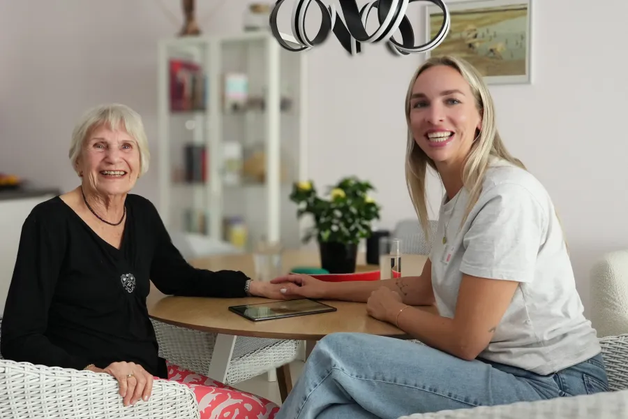 Casemanager dementie en cliënt zitten samen aan tafel