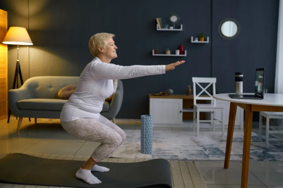 Vrouw die thuis sport achter laptop - thuis sporten.png